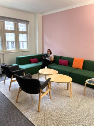 Miriam Schumm liest das Buchjournal auf einer Couch im Haus des Buches