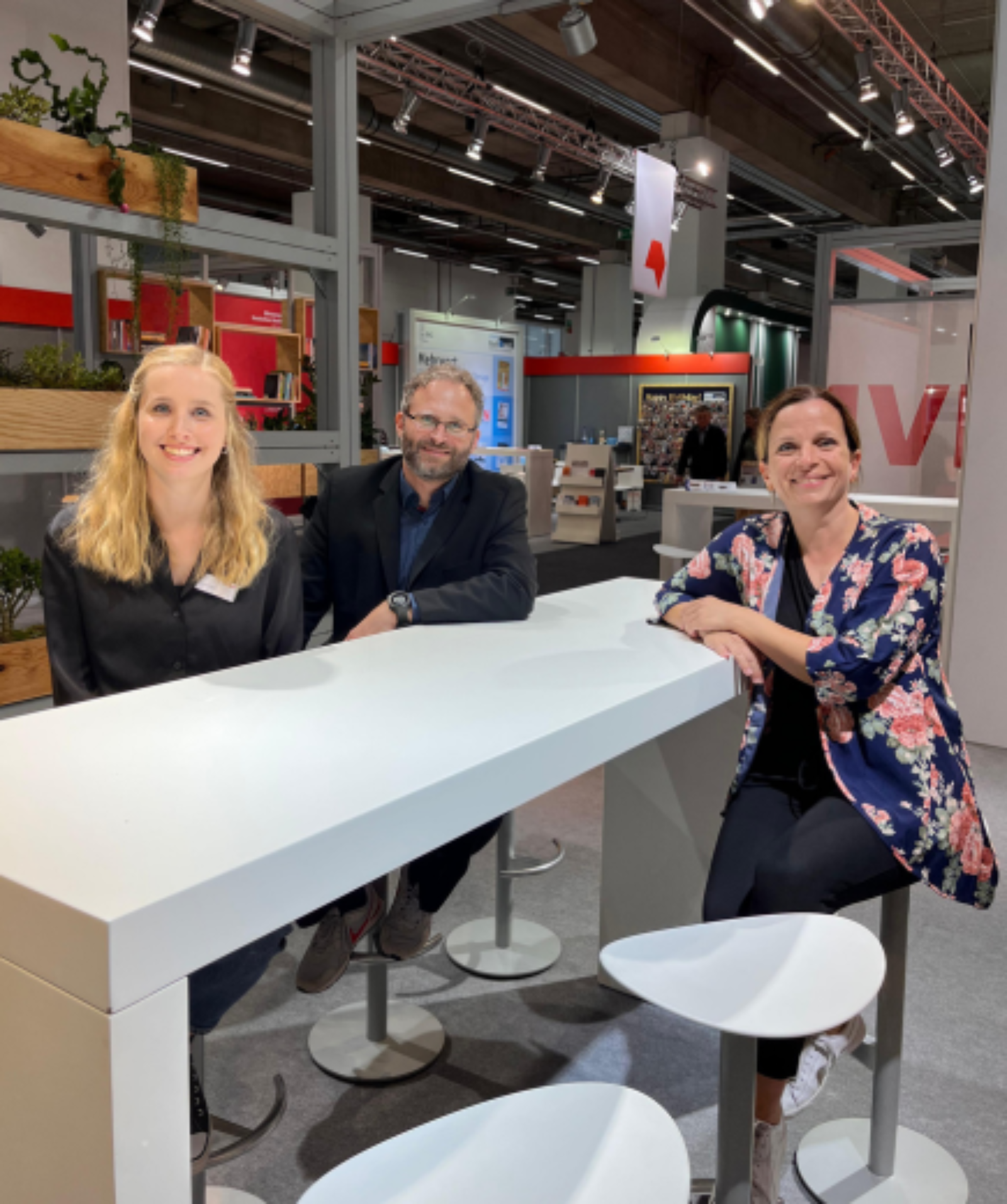 Mitarbeiter sitzen an einem Tisch am Messestand